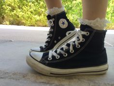 a person wearing black and white converse shoes