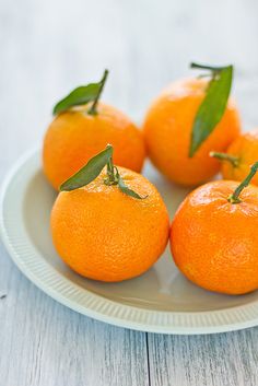 there are many oranges in the box on the wooden table and one is half eaten