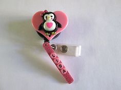 Adorable Penguin on a pink heart attached to a ID Badge retractable reel with your name on a pink bar attached to the badge.  The name on the picture is a sample.  Please e mail me the name you want at the time of purchase.  It can be no more than 7 letters. Adjustable Novelty Pink Badge Holders, Cute Pink Badge Holders For Gift, Cute Pink Badge Holder As Gift, Cute Pink Badge Holders As Gift, Fun Pink Badge Holders For Gift, Novelty Pink Badge Holder For Birthday, Cute Pink Badge Reel For Birthday, Pink Personalized Novelty Badge Reel, Novelty Personalized Pink Badge Reel