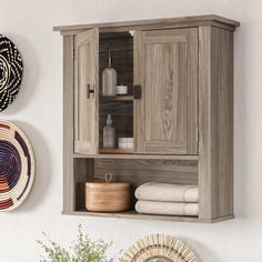 a wooden cabinet sitting on top of a wall next to a basket and bowl with towels