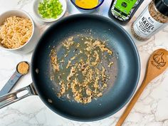 an empty frying pan filled with food on top of a white marble countertop