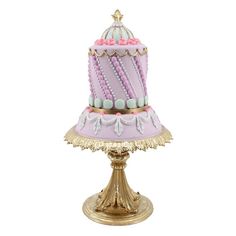 a pink and gold cake sitting on top of a golden stand with white frosting