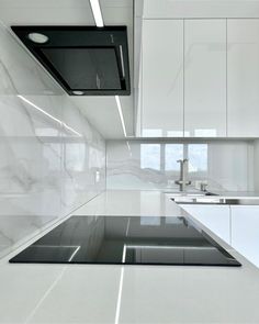 a kitchen with white cabinets and black counter tops in the center, along with an island style sink