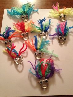 five colorful hair clips with eyes and googly eyes on top of a piece of paper