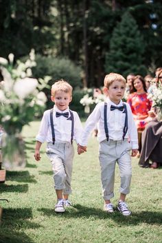 two young boys walking down the aisle at a wedding