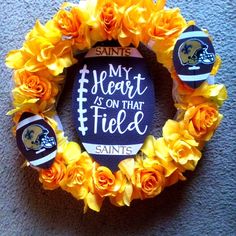 a wreath made out of flowers with the words my heart is on that field painted on it