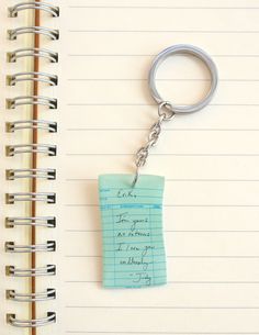 a note pad with a keychain attached to it