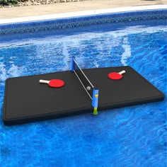 two ping pong paddles on top of an inflatable swimming pool table