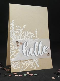 a card with the word hello written in white on it and some coins scattered around