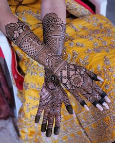 a woman's hands with hennap on her hand and the other arm