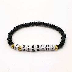 I Dissent Stackable Stretch Bracelet. Seed Glass Beads. Color Black, White And Gold. 1 Bracelet. Measures 6.5 In. Handmade. Rbg, I Dissent, Friendship Bracelet, Be Kind, Love, Jewelry, Feminist, Girl Power, Notorious. Feminist Bracelet, I Dissent, Black Bangle, Black White And Gold, Glass Bead Bracelet, Slap Bracelets, Swarovski Bracelet, Enamel Bangle, Love Jewelry