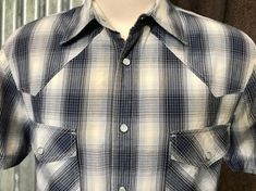 1990's Levi's vintage western short sleeve shirt.  Grey and blue plaid with snaps for closure. Size Medium. Measurements: Chest: 112 cm / 44 inches Length: 72 cm / 28 inches                                                                                  Shoulders: 48 cm / 19 inches                                                                                       Sleeve: 22 cm / 19 inches This item is one of a kind. BUYING VINTAGE: While all care is taken to state any obvious faults, please note that when you buy a vintage or preloved item, they may show small signs of ageing, wear and/or repair. Visit my new website   https://phoenixmenswear.com.au/ Lots of fun stuff for guys and girls...!! Please note that if you are ordering from anywhere outside of Australia please add your phone n Fitted Plaid Western Tops, Fitted Western Plaid Tops, Western Plaid Tops For Ranch, Western Style Plaid Flannel Shirt For Ranch, Western Style Plaid Shirt For Rodeo, Western Plaid Shirt For Rodeo, Western Plaid Flannel Shirt For Rodeo, Western Style Summer Shirt With Snap Buttons, Western Style Short Sleeve Shirt For Rodeo