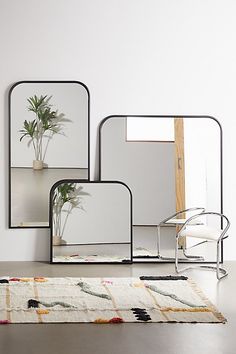 three mirrors and a plant on a table