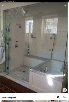 a bathroom with white tile and glass shower doors