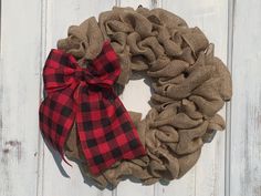 a burlap wreath with a red and black plaid bow