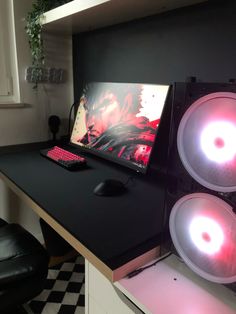 two speakers sitting on top of a desk next to a laptop computer and mouse pad