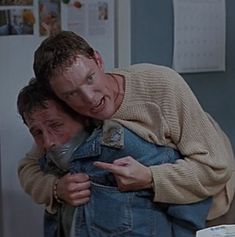 two men hugging each other in the kitchen