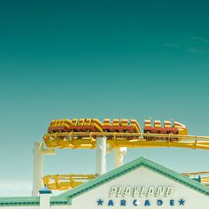 an amusement park ride with cars on it's top and the sky in the background