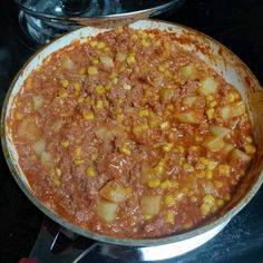 a pan filled with food sitting on top of a stove next to a frying pan