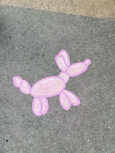 a drawing of a pink dog on the ground next to a person's foot