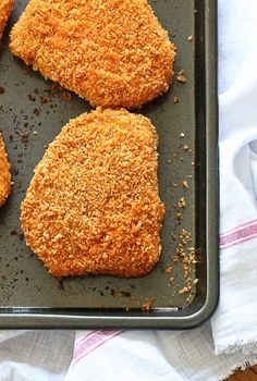 four fried chicken patties on a baking sheet