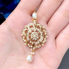 This 22ct gold pearl pendant set is intricately crafted with a floral pattern and embellished with freshwater seed pearls. It weighs 11.50 GMs and is an ideal choice for someone with a classic taste in jewellery, making it a perfect gift for special occasions. Price Breakup Summary Component Rupees % of Total 22k Gold 51,928 75.9% Stones & Beads 5,170 7.6% Making Charges 9,347 13.7% Taxes (GST) 1,993 3.0% Total 68,439 100.0% View Detailed Price Breakup. Watch Video Here Pearl Pendant Set, 22k Gold Jewelry Necklaces, 22k Gold Jewelry, Pearl Gifts, Pearl Necklace Set, Gold Jewelry Necklace, Real Pearls, Gold Bangle Bracelet, Gold Jewelry Fashion