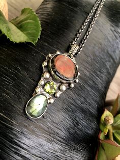 "Artisan Ammolite Fossil Gemstone Pendant Necklace Hand-made Sterling Silver 925 Stones used: Ammolite-Fossil, Labrodorite, Peridot. Height - 2 1/2\" (with bail), Width - 1 1/8\" Height -62mm (with bail), Width - 28mm Unique Handcrafted One-of a-kind Design Each Piece of Jewelry in my Collection is Absolutely One of a Kind! When you start wearing a piece of my jewelry you will fall in love with it more and more each day and feel that good Energy and Love that I pass into it while creating this p Artisan Hand Forged Sterling Silver Necklace, Artisan Necklace With Natural Tourmaline Stones, Silver Tourmaline Gemstone Necklace, Artisan Tourmaline Necklace With Natural Stones, Unique Labradorite Gemstones For Jewelry Making, Artisan Multi-stone Necklaces For Gifts, Fusion Style Tourmaline Jewelry With Natural Stones, Handmade Fusion Style Sterling Silver Necklace, Artisan Round Multi-stone Necklace