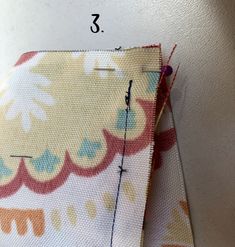 two pieces of fabric that are next to each other, with the sewing needle in between them