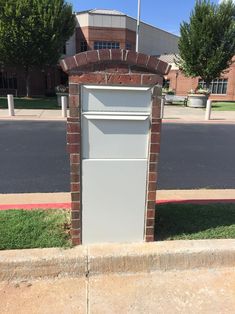 a sign that is on the side of a brick wall in front of a building