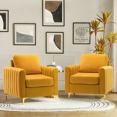 two yellow chairs sitting on top of a white rug in front of pictures hanging on the wall