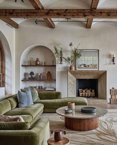 a living room filled with furniture and a fire place in the middle of an open floor plan