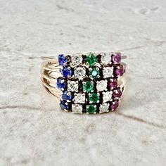 Vintage handcrafted 14 karat yellow gold natural ruby, sapphire, emerald and diamond band ring. The ring is made of five 5-stone bands attached together. It is set with 10 transitional old cut and round diamonds (0.40 CTTW, F-G VS-SI), 5 round rubies (0.25 CTTW), 5 round blue sapphires (0.25 CTTW) and 5 round emeralds (0.15 CTTW). Total carat weight of all the gemstones is 1.05 carat. Circa 1960. Weighs 6.3 grams. Ring Size 6.75 US / N UK. W: 12.65 mm. Tested for 14k gold. Birthstone: April/May/ Emerald And Diamond Band, Ruby Band Ring, Yellow Gold Cocktail Ring, Ruby Bands, Antique Jewelry Rings, Gold Cocktail Ring, Birthday Ring, Best Gifts For Her, Ruby Sapphire