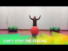 a woman standing on top of a red ball in front of green and yellow balls