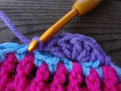 the crochet is being worked on with a knitting needle