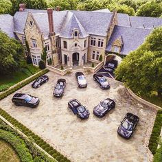 an aerial view of a mansion with many cars parked in front