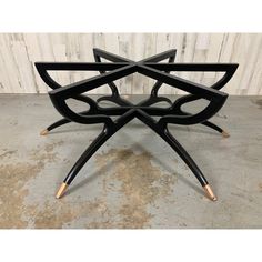 a set of four black and gold chairs with wooden legs, designed to look like an abstract