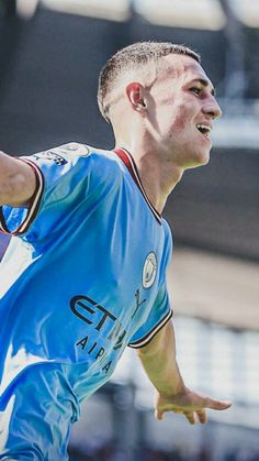 a young man is playing soccer on the field with his hands out to catch the ball