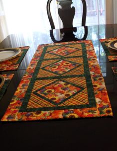 the table is set with plates and place mats on it, along with a vase