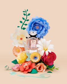 a bouquet of paper flowers with a perfume bottle in the middle