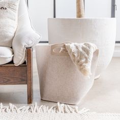 a chair and some pillows on the floor in front of a wall mounted planter