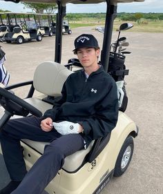 a young man sitting on top of a golf cart