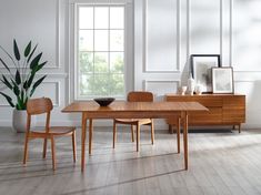 a wooden table and chairs in a white room