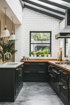 a kitchen with black cabinets and white brick walls is featured on the instagram page