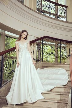 a woman in a wedding dress standing on some stairs