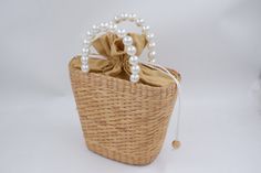 pearl straw bag, woven bag with pearl handle, bridesmaid Gift, bridal party gifts, wedding favour bags, birthday gift Straw Weave Handbag is 100% handcrafted by local Thailand artists, from a water hyacinth. The work is exquisite and of a very high quality. the bags is created with love and hand worked,that makes it unique and one of a kind also a perfect bag or gift for a girl - ++ Detail ++ Approx size : Wide 10 cm (bottom of bag 16 cm) Length 23 cm Height 20 cm Made from : water hyacinth with faux pearl  HOW TO CARE  1. Avoid humidity and expose them to the sun often. 2. Spot clean with damp cloth SHIPPING: # Processtimes 3-5 days # We will be SHIPPED via THAI AIRMAIL and had TRACKING No. # and Delivery Time 1-5 week Contact me if you want large quantity for wholesale Thank You ♥ NORNOR Elegant Beige Straw Bag With Pearl Handle, Elegant Beach Straw Bag With Pearl Handle, Elegant Straw Bag With Pearl Handle For Beach, Elegant Straw Bag With Pearl Handle For Vacation, Elegant Natural Straw Bag With Pearl Handle, Elegant Summer Straw Bag With Pearl Handle, Elegant Straw Bag With Pearl Handle, Elegant Handwoven Straw Bag For Gift, Elegant Handmade Summer Straw Bag