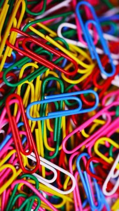 many different colored paper clips stacked together