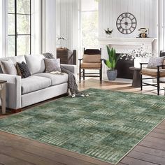 a living room filled with furniture and a large rug on top of a hard wood floor