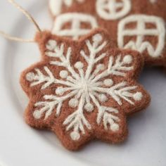 two brown and white snowflake ornaments on a plate