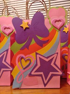 some paper bags with hearts, stars and other decorations on them sitting on a table