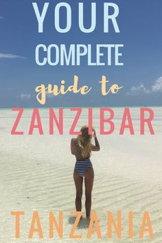 a woman standing in the sand with text overlay that reads your complete guide to zanzibar